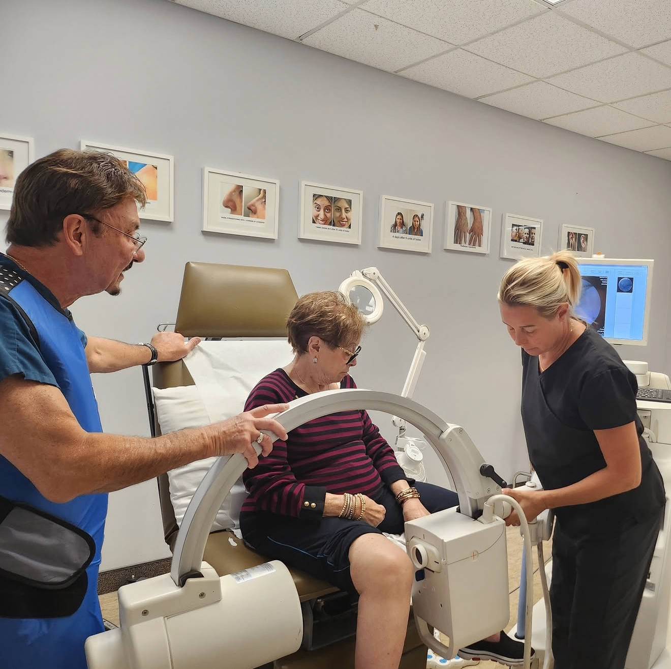 Dr. Fretta and a team member attending to a seated patient with treatment equipment